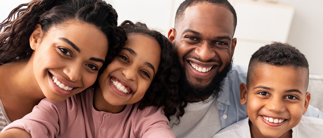 Smiling parents and two children pictured together
